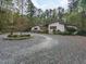 Beautiful single-story home with a circular driveway surrounded by mature trees and landscaping at 1604 Meadow Ln, Chapel Hill, NC 27516