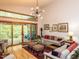 Bright living room with hardwood floors, modern light fixture, neutral walls and furniture, and a view of the outdoor deck at 1604 Meadow Ln, Chapel Hill, NC 27516