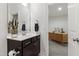 Bathroom with a modern vanity, decorative plant, and a glimpse into an adjacent office space with a built-in desk at 184 Wildfell Trl, Cary, NC 27513
