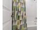 Bright bathroom featuring a clean white tiled shower and geometric shower curtain, offering a modern, fresh feel at 184 Wildfell Trl, Cary, NC 27513