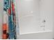 Bright bathroom featuring a pristine white shower/tub combination and a colorful floral-patterned shower curtain, enhancing the spa-like ambiance at 184 Wildfell Trl, Cary, NC 27513