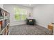 Bright bedroom featuring a chair near the window, a bookshelf and modern geometric-patterned carpet at 184 Wildfell Trl, Cary, NC 27513