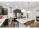 Contemporary kitchen with stainless steel appliances, dark cabinets, and a central island with seating at 184 Wildfell Trl, Cary, NC 27513