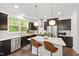 Well-lit kitchen with modern appliances, white countertops, and sleek dark cabinetry at 184 Wildfell Trl, Cary, NC 27513