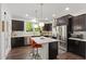 Modern kitchen features stainless steel appliances, dark cabinets, and an island with quartz countertop at 184 Wildfell Trl, Cary, NC 27513