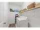 Well-organized laundry room with modern appliances, overhead shelving, and a colorful rug, providing practical functionality at 184 Wildfell Trl, Cary, NC 27513