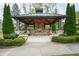 Covered outdoor seating area featuring a stone fireplace, benches, and landscaped surroundings at 184 Wildfell Trl, Cary, NC 27513