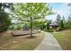 Community playground and outdoor kitchen with covered seating area and green space at 184 Wildfell Trl, Cary, NC 27513