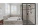 This bathroom features a soaking tub, walk-in shower, and a window with white shutters at 200 Windy Knoll Cir, Chapel Hill, NC 27516