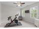 Bright exercise room with a peloton bike, chair, TV, and natural light from the windows at 200 Windy Knoll Cir, Chapel Hill, NC 27516