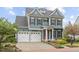 Charming two-story home boasts a red door, three-car garage, and professionally landscaped front yard at 200 Windy Knoll Cir, Chapel Hill, NC 27516