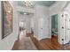 Hallway featuring hardwood floors, elegant trim, a chandelier, and a view into the living and dining rooms at 200 Windy Knoll Cir, Chapel Hill, NC 27516