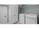 Well-organized laundry room with modern washer and dryer, storage cabinets, and shelving at 200 Windy Knoll Cir, Chapel Hill, NC 27516