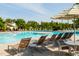 Community swimming pool with many lounge chairs and a sun umbrella at 200 Windy Knoll Cir, Chapel Hill, NC 27516