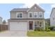 Charming two-story home with a two-car garage, stone accents, and a well-manicured lawn at 205 Loxton St, Fuquay Varina, NC 27526