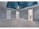Large bedroom with a tray ceiling, ceiling fan, carpet, and en-suite bathroom access at 205 Loxton St, Fuquay Varina, NC 27526