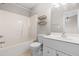 Bathroom with a shower-tub combo, white vanity, and wood shelves at 2101 Piney Brook Rd # 105, Raleigh, NC 27614