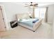 Serene bedroom with carpet, large window, ceiling fan, and a stylish bed with bedside tables and lamps at 2123 Gregor Overlook Ln, Apex, NC 27502