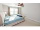 Bright bedroom featuring a window and fan, complemented by a bed with neutral upholstered frame at 2123 Gregor Overlook Ln, Apex, NC 27502