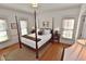 Cozy bedroom featuring a four-poster bed, hardwood floors, and natural light from two windows at 228 Old Colony Way, Rocky Mount, NC 27804