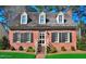 Charming brick home featuring a cedar shake roof and dormer windows, offering classic curb appeal at 228 Old Colony Way, Rocky Mount, NC 27804