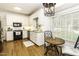 Bright eat-in kitchen featuring white cabinetry, modern appliances, and hardwood floors at 228 Old Colony Way, Rocky Mount, NC 27804