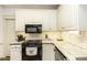 Well-lit kitchen with white cabinets, modern appliances, and a charming design at 228 Old Colony Way, Rocky Mount, NC 27804