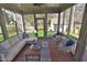 A delightful screened porch features brick floors, comfortable seating, and views of the backyard and outbuilding at 228 Old Colony Way, Rocky Mount, NC 27804