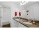 Bright bathroom featuring double sinks with granite countertops, white cabinets, and modern fixtures at 2308 Swansea Ln, Apex, NC 27502