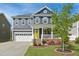 Charming two-story home with a welcoming porch, brick accents, and well-manicured lawn at 2308 Swansea Ln, Apex, NC 27502