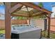 Close-up of a bubbling hot tub beneath a wooden gazebo in a fenced backyard at 2308 Swansea Ln, Apex, NC 27502