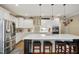 Bright kitchen featuring white cabinets, modern appliances, and a spacious island with seating at 2308 Swansea Ln, Apex, NC 27502
