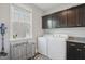 Functional laundry room with a washer, dryer, storage cabinets, and a window for natural light at 2308 Swansea Ln, Apex, NC 27502