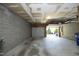 Unfinished basement with block walls, concrete floor, and an open garage door at 233 Sweet Bay Pl, Carrboro, NC 27510