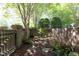 Secluded courtyard featuring a brick wall surround, mulch, and a variety of green vegetation at 233 Sweet Bay Pl, Carrboro, NC 27510