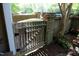 Wooden gate with brick accents and lush greenery, leading to a private courtyard area at 233 Sweet Bay Pl, Carrboro, NC 27510