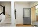 Welcoming entryway with hardwood floors, gray door, and stairs with black handrail at 233 Sweet Bay Pl, Carrboro, NC 27510