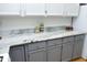 Kitchen featuring gray cabinets, stainless hardware, and a granite countertop with decor and storage at 233 Sweet Bay Pl, Carrboro, NC 27510
