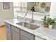 Close-up on the kitchen sink and countertops with granite counters, gray cabinets, and a modern faucet at 233 Sweet Bay Pl, Carrboro, NC 27510