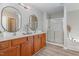 Bathroom with double vanities, decorative mirrors, quartz counters, and a tiled shower at 3047 Kilarney Ridge Loop, Cary, NC 27511