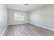 Bright bedroom features wood-look flooring, neutral paint, and a window with horizontal blinds at 3047 Kilarney Ridge Loop, Cary, NC 27511