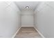 Empty walk-in closet features custom storage, recessed lighting and wood-look floors at 3047 Kilarney Ridge Loop, Cary, NC 27511