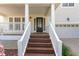 Inviting front porch with classic white railings and wooden steps leading to the front door at 3047 Kilarney Ridge Loop, Cary, NC 27511