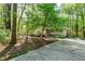Home exterior with mature trees, wood accents, colorful landscaping, and a stone driveway, with a charming one-story facade at 3217 Brennan Dr, Raleigh, NC 27613