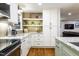 Modern kitchen features granite counters, white cabinets, open shelving, and stainless steel appliances at 3217 Brennan Dr, Raleigh, NC 27613