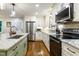 Well-lit kitchen featuring granite countertops, modern appliances, custom cabinets, and hardwood flooring at 3217 Brennan Dr, Raleigh, NC 27613
