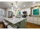 Bright kitchen with granite counters, stainless appliances, and eat-in island with pendant lighting at 3217 Brennan Dr, Raleigh, NC 27613