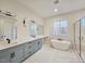 Modern bathroom with dual vanities, a soaking tub, a walk-in shower, and sleek fixtures at 35 Big Bear Dr, Pittsboro, NC 27312