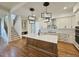 Modern kitchen featuring hardwood floors, an island, white cabinets, stainless steel appliances, and pendant lighting at 35 Big Bear Dr, Pittsboro, NC 27312
