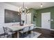 Dining room with a modern light fixture and table for six overlooking the backyard at 357 Fosterton Cottage Way, Raleigh, NC 27603